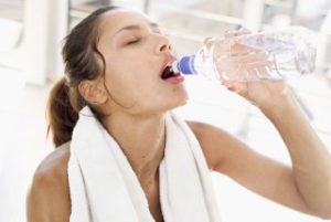 ヨガレッスン中に水を飲む女性