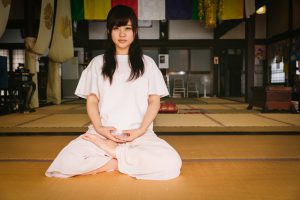 畳の上で座ってヨガをする女性