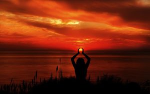 夕日の中でヨガをする人物