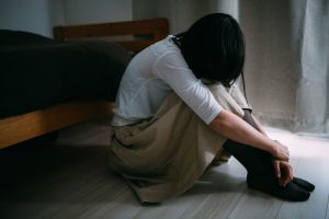 うつむいて座る女性