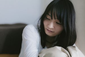 ベッドで肩を押さえる女性