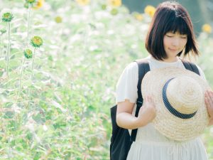 草原で帽子を持つ女性
